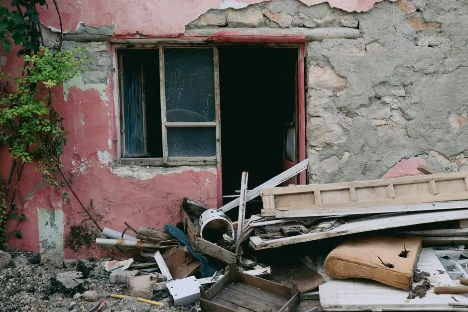A damaged building facade showing broken windows and scattered rubble, illustrating urban decay.