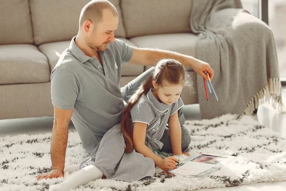 Father and daughter coloring together on the living room floor, enjoying quality time.